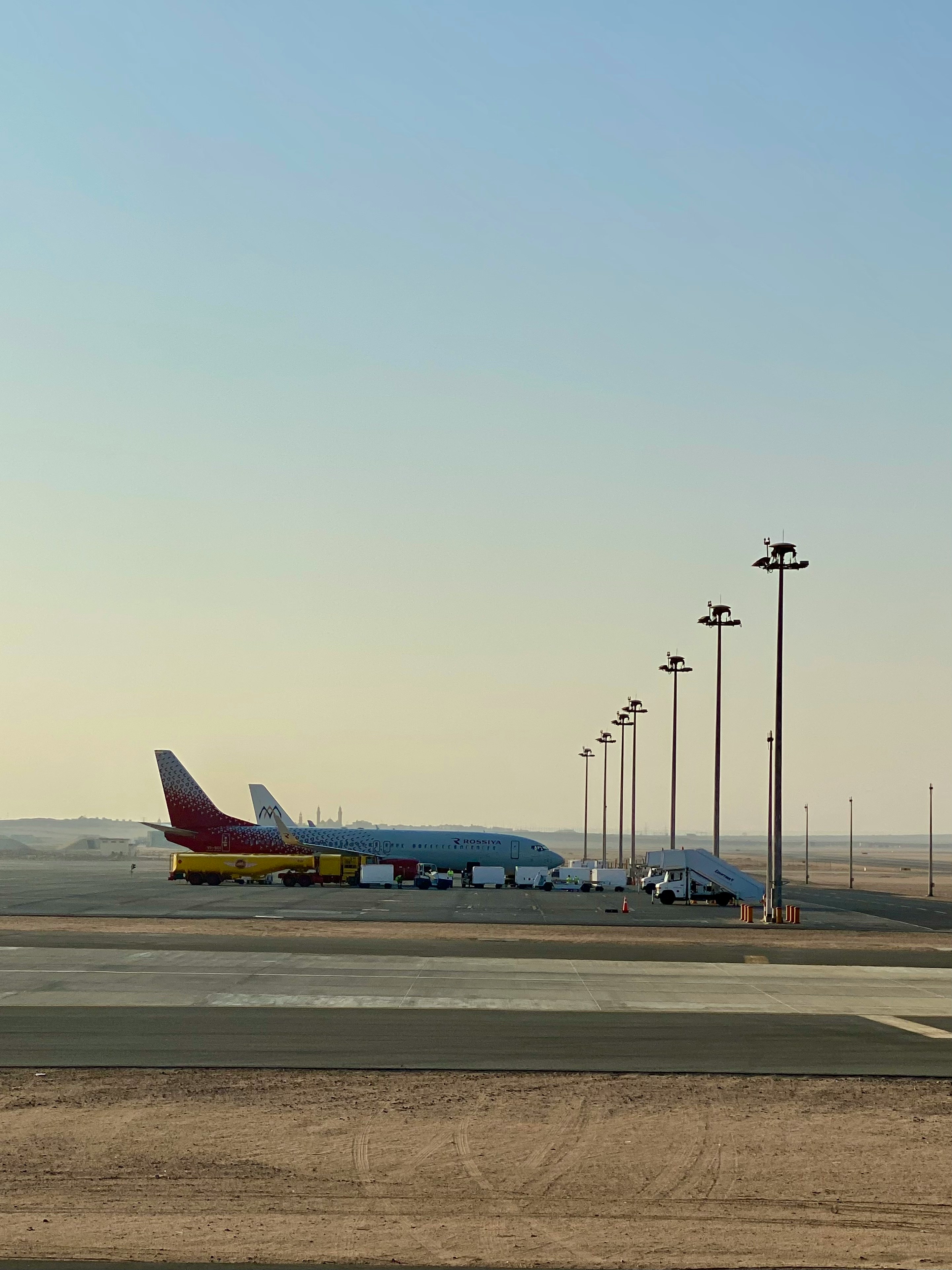 Sunset over airport terminal roofs